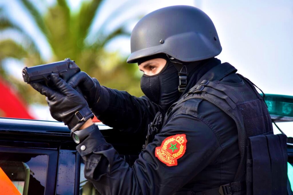 عنصر أمني يشهر سلاحه الوظيفي